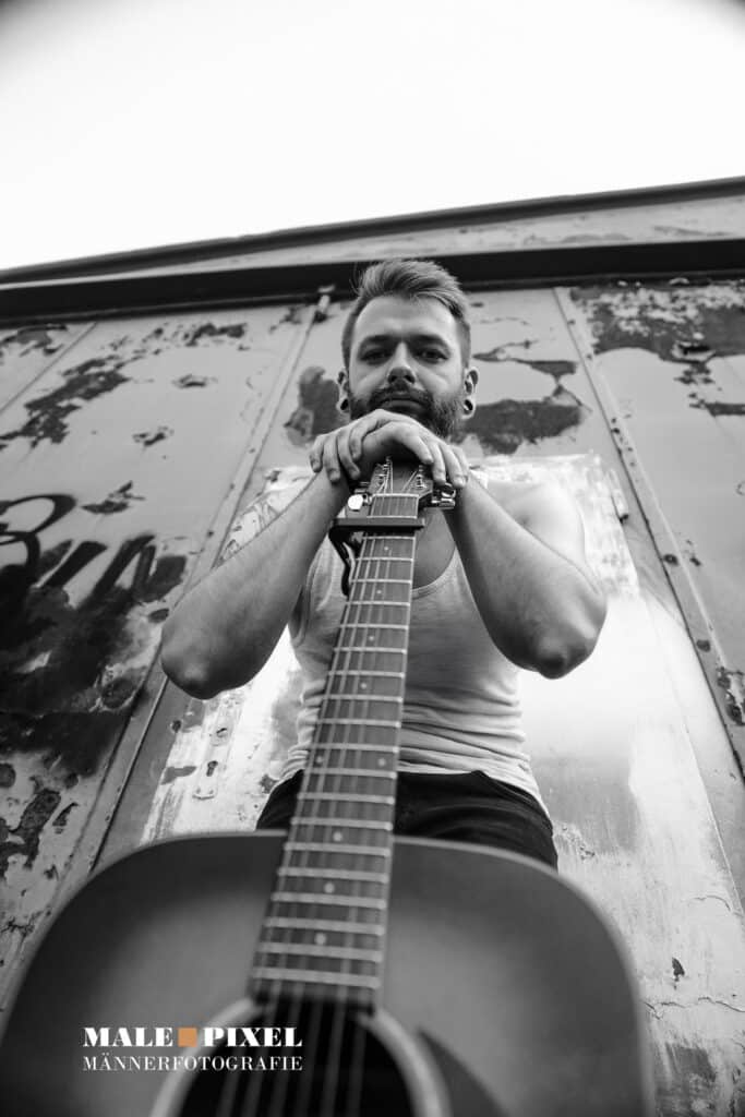 Männerportrait frontal mit Gitarre