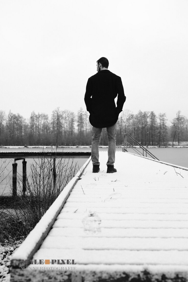 Schwarzweiß Männerportrait Outdoor am winterlichen See mit ruhiger und minimalistischer Bildwirkung